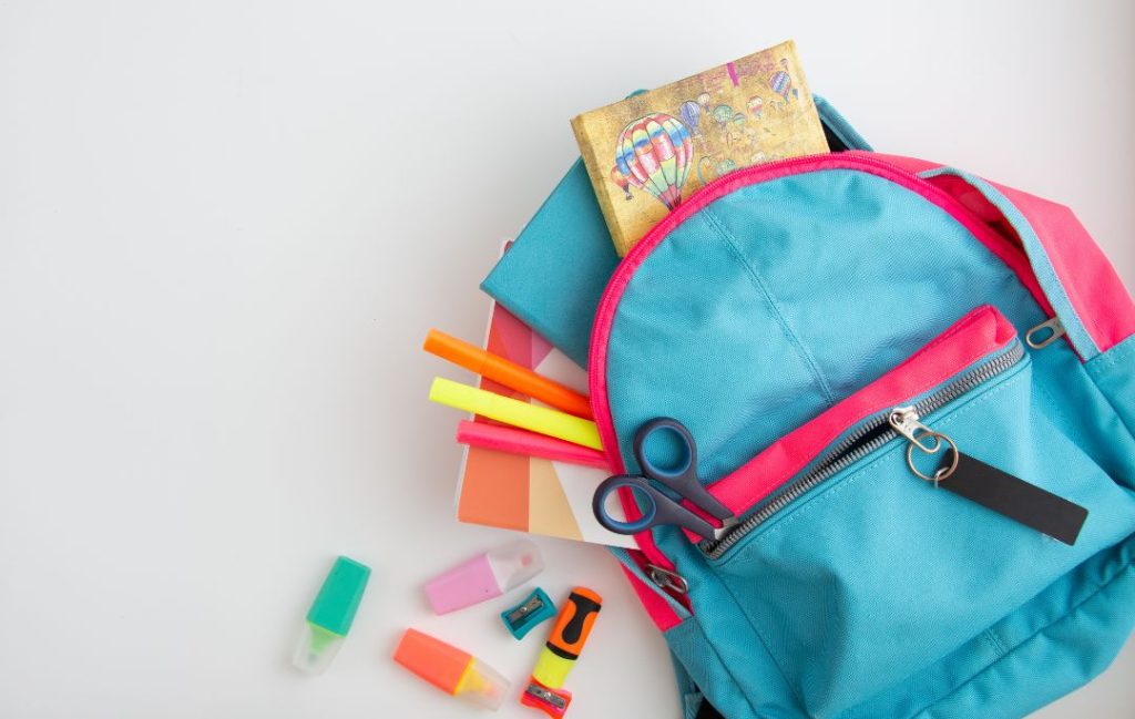 Aparece diferentes materiales escolares en una mochila para la vuelta al cole